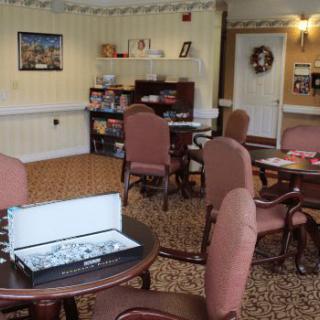 A cozy recreation room with tables and chairs, featuring a chess set ready for play.