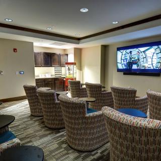 A cozy home theater room with comfortable seating and a large TV screen.