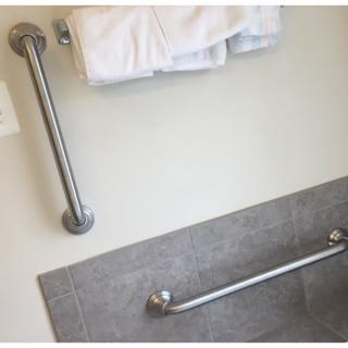 A bathroom featuring metal grab bars and a white towel.