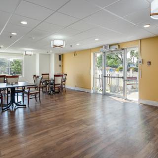A bright and modern dining area featuring wooden flooring and ample seating.
