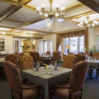 A beautifully decorated dining room with elegant chandeliers and neatly arranged tables.