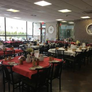 An indoor dining area with tables and chairs set up in a restaurant.