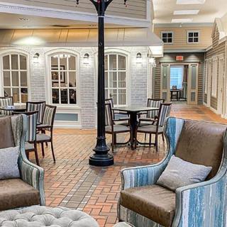 A cozy indoor seating area with comfortable chairs and tables, styled like a street scene.