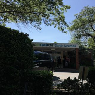 A sunny day at a restaurant entrance surrounded by greenery.