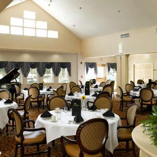 A beautifully arranged dining area with elegant tables and a piano.