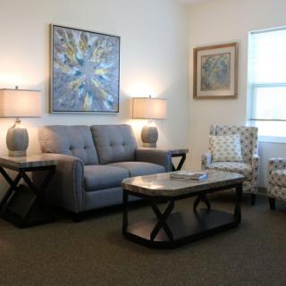 A cozy living room with a sofa, coffee table, and decorative artworks on the walls.
