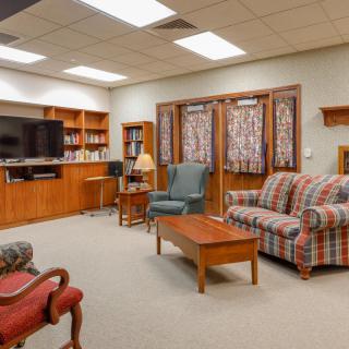 Cozy living room with a comfortable sofa, armchairs, and a large television.
