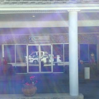 A storefront with reflections and a parked vehicle.
