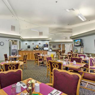 An empty dining area in a restaurant with neatly arranged tables and chairs.