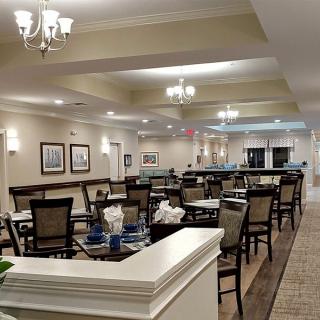 A spacious and elegantly designed dining area with neatly arranged tables and chairs under soft lighting.