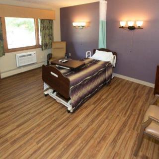A clean and organized hospital room with a single bed and modern amenities.