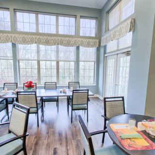 A modern dining room with large windows and ample natural light.