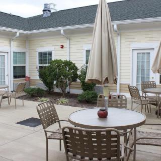 A cozy courtyard with tables, chairs, and umbrellas for outdoor seating.