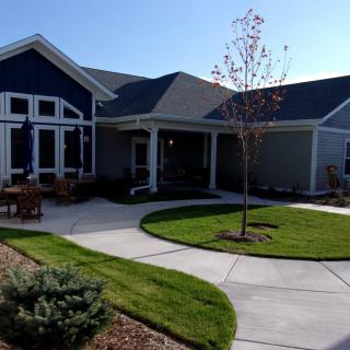 A suburban house with a well-kept lawn and driveway.