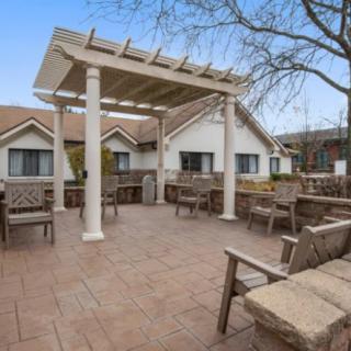 A spacious outdoor patio with a pergola and comfortable seating.