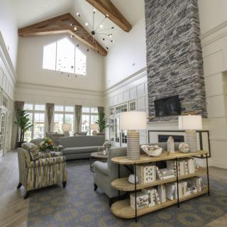 Spacious modern living room with high ceilings and a stone fireplace.