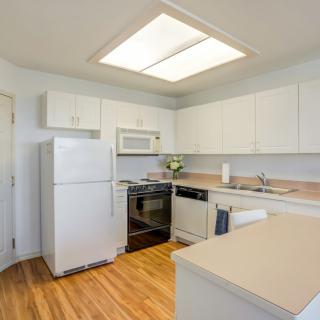 Modern kitchen with white cabinets and appliances.