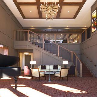 A spacious lobby featuring elegant interior design with a grand staircase and chandelier.
