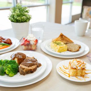 A delicious spread featuring a hearty main course, vibrant vegetables, and delightful desserts.