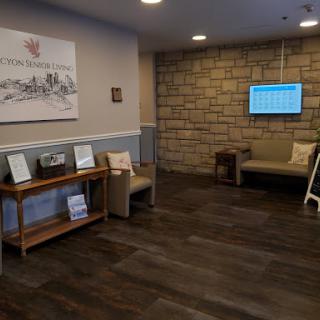 A cozy and modern lobby area featuring comfortable seating and an information screen.