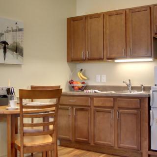 A cozy kitchen with wooden cabinets and a small dining area.