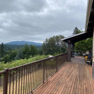 A wooden deck overlooking a scenic mountain view under a cloudy sky.