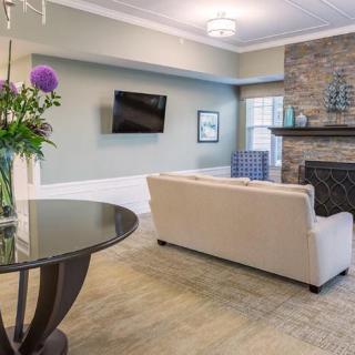 A cozy living room with a sofa, fireplace, and a TV mounted on the wall.
