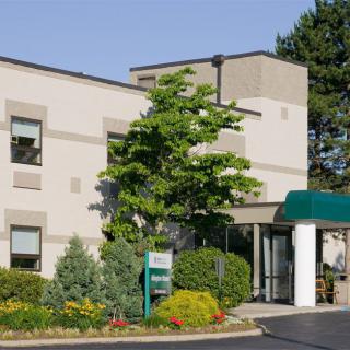 A hotel building with a landscaped entrance and greenery.
