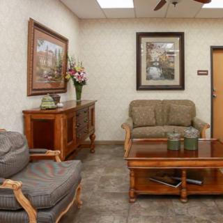 A cozy waiting room with comfortable seating and decorative artwork on the walls.