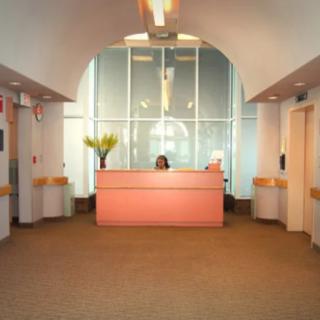 A modern office lobby with a reception desk and decorative lighting.