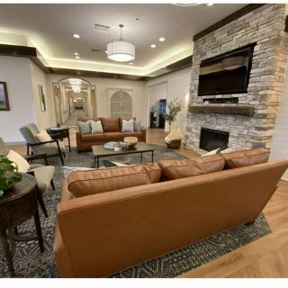 A modern living room featuring comfortable sofas, a stone fireplace, and elegant lighting.