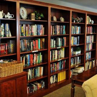 A cozy reading room with wooden bookshelves filled with a variety of books.