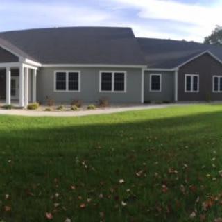 A single-story suburban house with a spacious lawn and a modern design.