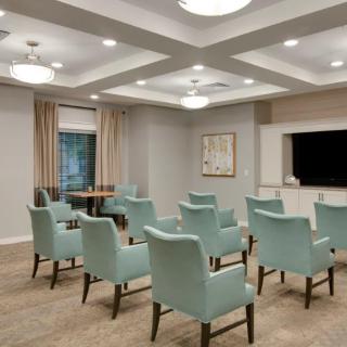 A modern conference room with neatly arranged chairs and contemporary lighting.