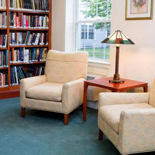 Cozy reading nook with armchairs and bookshelves.