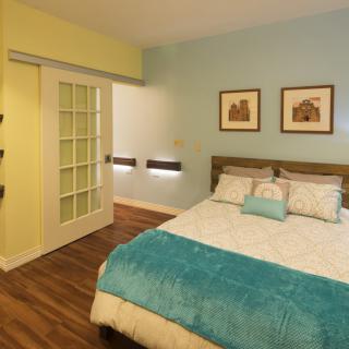 A cozy bedroom featuring modern decor, a sliding door, and blue accent colors.