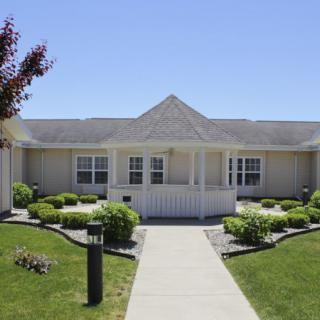 A single-story suburban house with well-maintained lawns and shrubs.