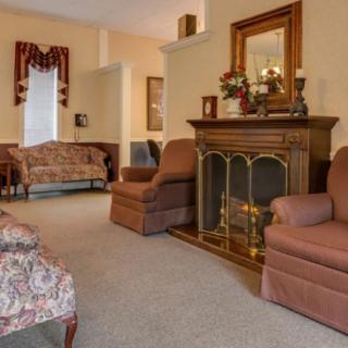 A cozy living room with a fireplace, decorated with traditional furniture and warm colors.