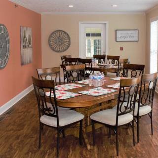 A cozy dining room with a wooden table and chairs, accented by wall decorations.