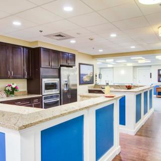 A modern kitchen interior featuring blue and white countertops with dark wooden cabinets and stainless steel appliances.