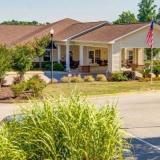 A well-maintained suburban house with a front porch and landscaped yard.