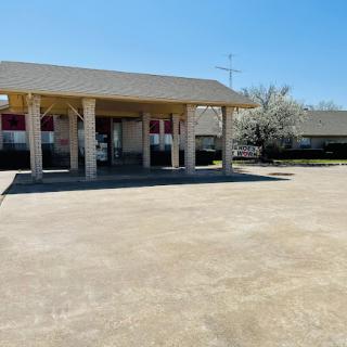 A sunny day view of a commercial building with a spacious parking lot.