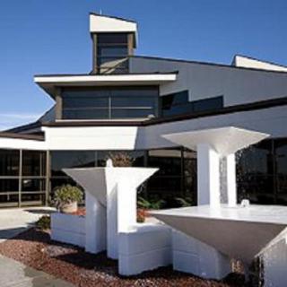 A modern building with a distinctive geometric design, featuring angular lines and white structures.