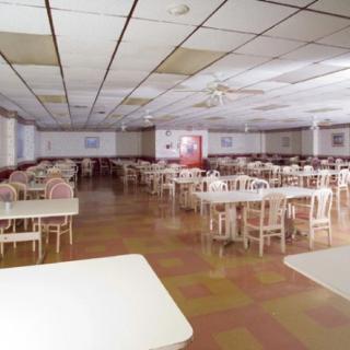 An empty dining hall with rows of tables and chairs ready for service.