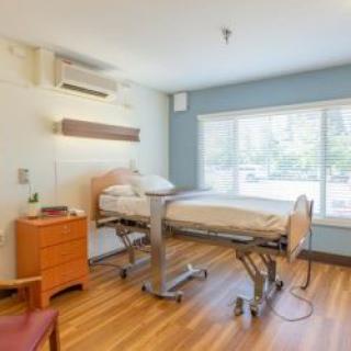 A clean and well-lit hospital room with a bed and window view.