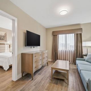 A cozy living room with a sofa, television, and wooden furniture.