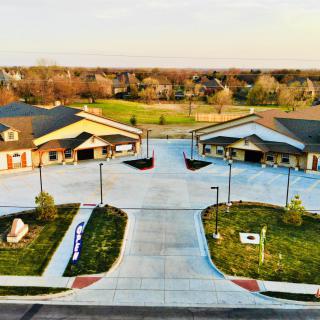 Aerial view of suburban buildings with landscaped driveways and greenery.
