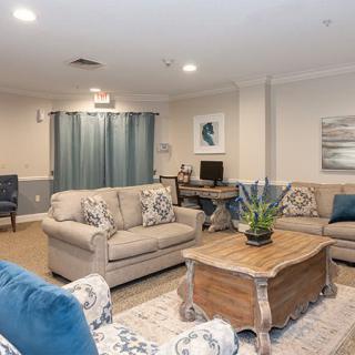 A cozy living room featuring beige sofas, a wooden coffee table, and elegant decor.