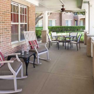A cozy porch with rocking chairs and a table set under a covered patio.