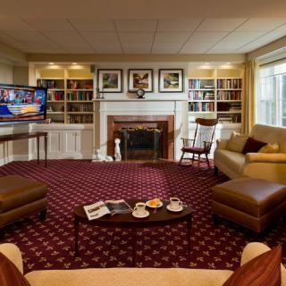 A cozy living room with a fireplace, bookshelves, and comfortable seating.